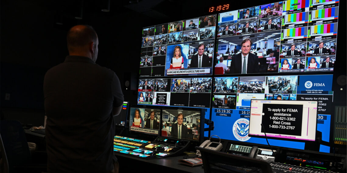 A federal official participates in a live news interview about Hurricane Helene relief during a visit to the Federal Emergency Management Agency in Washington, D.C., in 2024. (USDAgov, Public domain, via Wikimedia Commons)