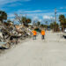 Workers walk past piles of debris in Fort Myers Beach, following the destruction caused by Hurricane Ian. (iStock photo)