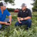 Extension agent Tyler Pittman, left, talks with watermelon farmer Garret Beach about using smart apps to monitor irrigation. (UF/IFAS photo)