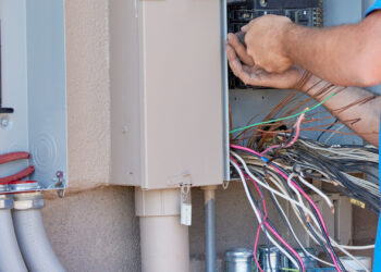 An electrician installing a transfer panel for a backup generator at a home (iStock image)