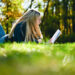 A woman reading a book in nature (iStock image)