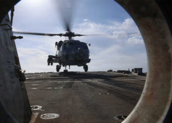 An MH-60R Sea Hawk helicopter lands on the flight deck of Arleigh Burke-class guided-missile destroyer USS Thomas Hudner (DDG 116) during flight deck operations while underway during Operation Epic Fury, Mar. 16, 2026. (NAVCENT Public Affairs, Public domain, via Wikimedia Commons)