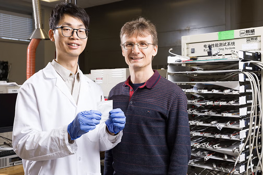 Doctoral student Peng Wang holds an aqueous zinc-ion battery beside Professor Petru Andrei in Andrei's lab at Florida State University’s Aero-Propulsion Mechatronics & Energy building. (Scott Holstein/FAMU-FSU College of Engineering)