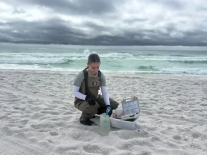 Natalie Larsen, a member of the Vibrio surveillance research team, gathers seawaters samples from Florida’s Pensacola Beach to test for vulnificus and other bacteria. (Courtesy of Natalie Larsen)