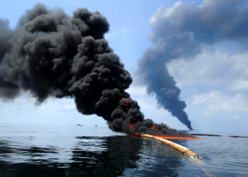 A controlled fire is conducted to help prevent the spread of oil in the Gulf of Mexico on May 6, 2010, following the BP Deepwater Horizon spill. (Petty Officer 2nd Class Justin Stumberg/U.S. Navy, Public domain, via Wikimedia Commons)