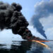 A controlled fire is conducted to help prevent the spread of oil in the Gulf of Mexico on May 6, 2010, following the BP Deepwater Horizon spill. (Petty Officer 2nd Class Justin Stumberg/U.S. Navy, Public domain, via Wikimedia Commons)