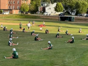 Football players at the New Hampton School in New Hampshire practice with less gear to help them acclimate to late summer heat during the first days of the preseason training. (Neal Morton/The Hechinger Report)