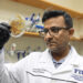 Imran Ahmad exams a saragassum sample in a lab. (FIU)