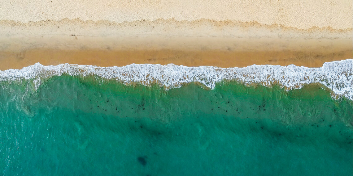 An aerial view of waves hitting a beach (iStock image)