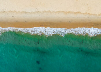 An aerial view of waves hitting a beach (iStock image)