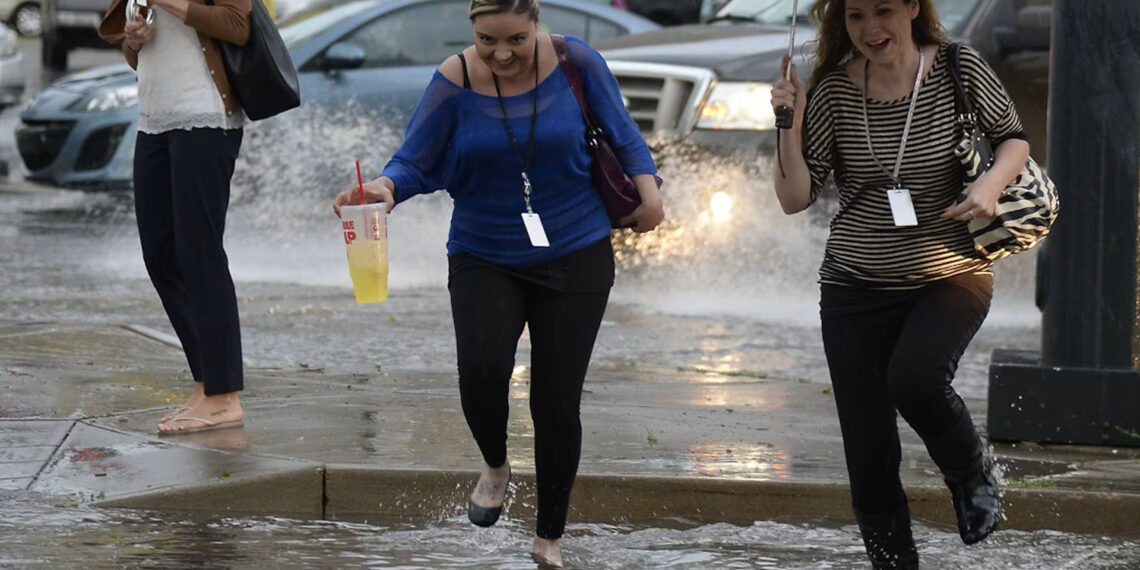 Pedestrians battle the wind, rain and flooded streets in downtown Denver. (Photo By John Leyba/The Denver Post via Getty Images)