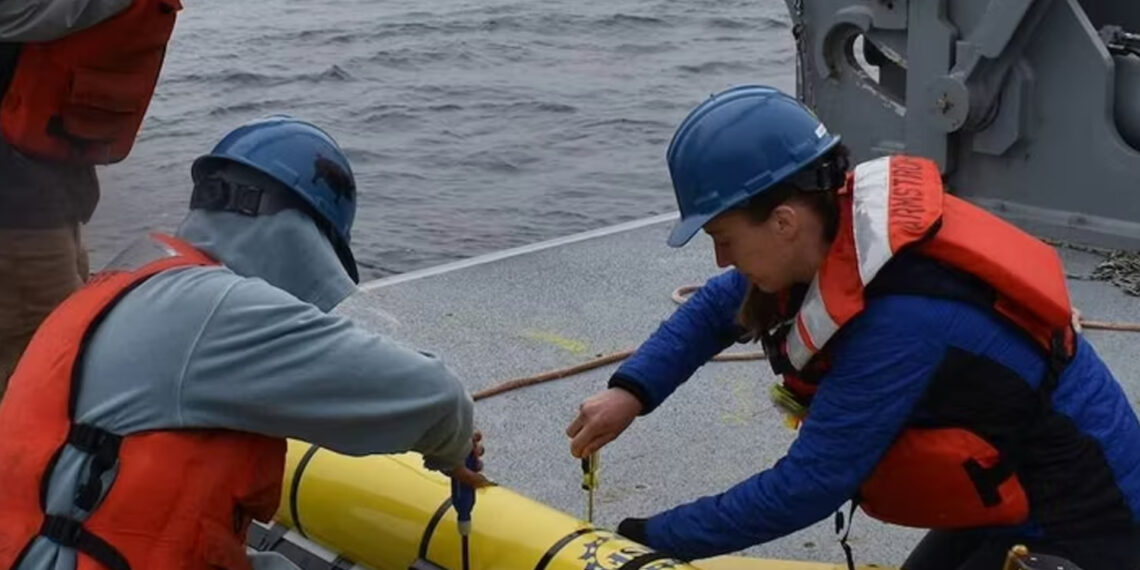 Researchers prepare to deploy a glider instrument into the ocean. (Photo by Rebecca Travis/Woods Hole Oceanographic Institution)