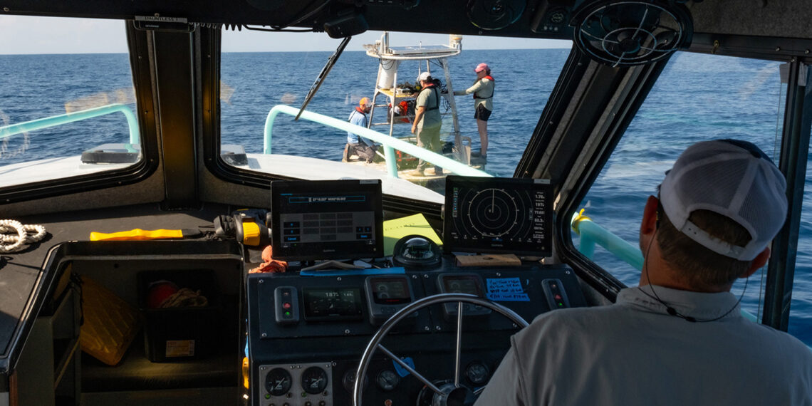 Ben Meister observes the crew members aboard a buoy in the Gulf. (Photo by Jackson Sullivan)