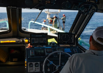 Ben Meister observes the crew members aboard a buoy in the Gulf. (Photo by Jackson Sullivan)