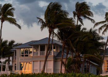 Wind blows palms in front of a Florida home (iStock image)